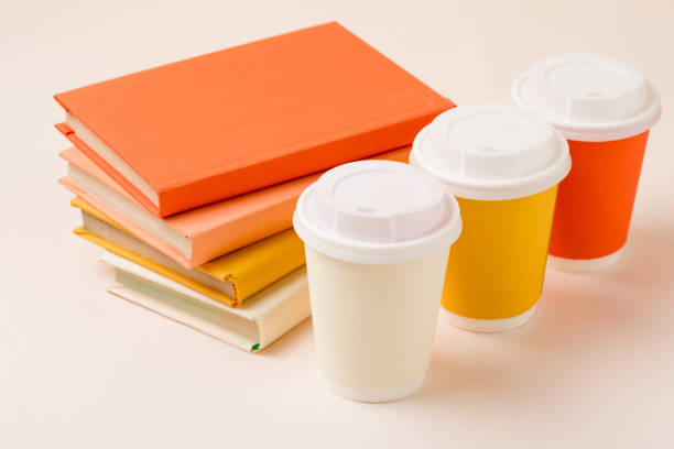 istock stack of books and colorful disposable cups on light surface 1152821149