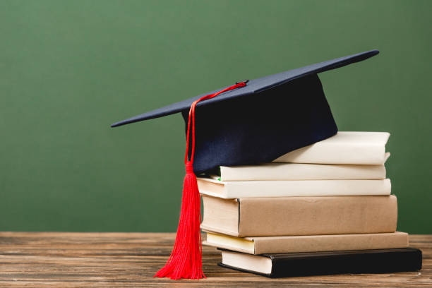 istock books and academic cap on wooden surface isolated on green 1152821190