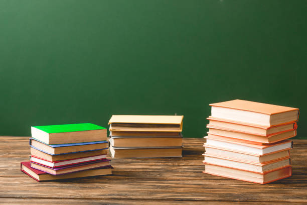 istock Stacks of books on wooden surface on green 1152821202