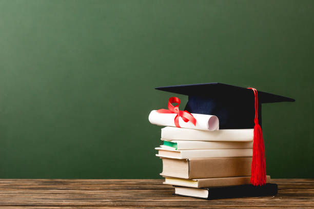 istock books, academic cap and diploma on wooden surface isolated on green 1152821208