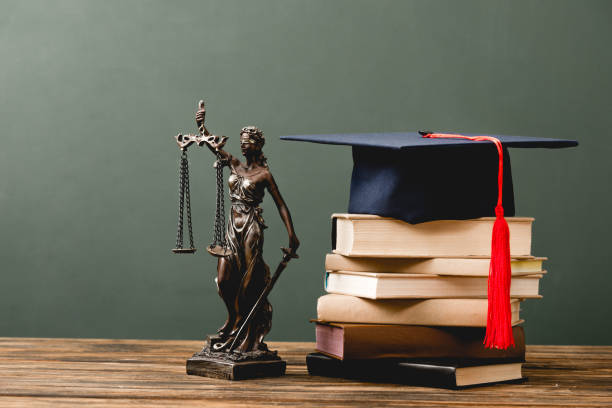 istock stack of books, themis statuette and academic cap on wooden surface on grey 1152821220