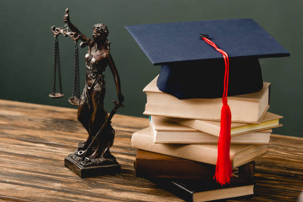 istock themis statuette, stack of books and academic cap on wooden surface on grey 1152821225