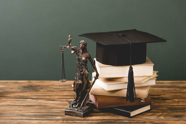 istock themis statuette, books and academic cap on wooden surface isolated on grey 1152821238