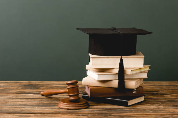 istock stack of books, academic cap and gavel on wooden surface isolated on grey 1152821242