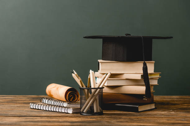 istock books, academic cap, notebooks, scroll, pencils on wooden surface isolated on grey 1152821266