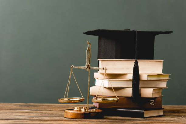 istock books, academic cap and scales on wooden surface isolated on grey 1152821281