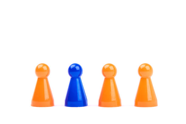 a series of orange game pieces and one different and exceptional blue figure as leader or boss - isolated on a white background - board game piece leisure games blue isolated imagens e fotografias de stock