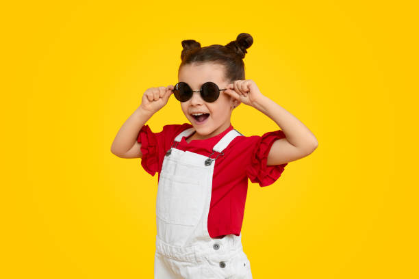 陽気な子供モデルは、スタイリッシュなサングラスを試着 - fashion model small one person happiness ストックフォトと画像