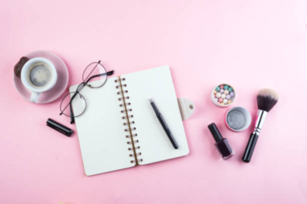 istock Workplace mockup with notebook, glasses and accessories on pink background top view. Flat lay with coffee copy space. Feminine working style concept. 1152823830