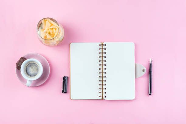 istock Morning coffee mug for breakfast, empty notebook, pencil and rose on pink table top view . Woman working desk. 1152823938