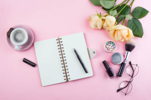 istock Workplace mockup with notebook, glasses, roses and accessories on pink background top view. Flat lay with coffee copy space. Feminine working style concept. 1152824020