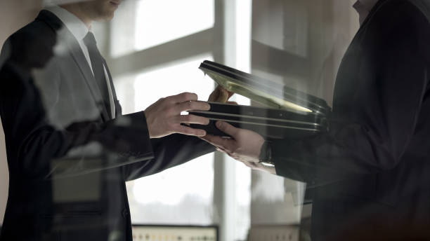 Businessman checking dollars in briefcase, kickback in illegal cooperation Businessman checking dollars in briefcase, kickback in illegal cooperation money laundering stock pictures, royalty-free photos & images