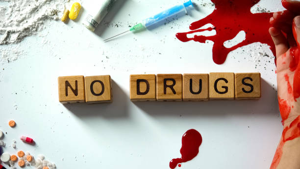 no drugs phrase on wooden cubes, bleeding hand and narcotics on table, concept - photography sign table ganja imagens e fotografias de stock