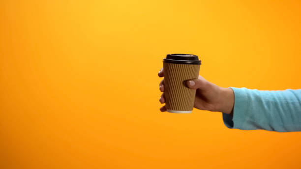 istock Female hand showing paper cup with beverage, inviting customers to cafeteria 1152830774