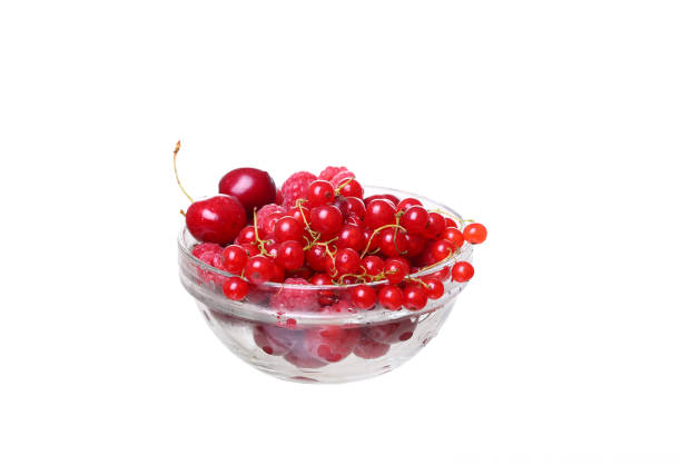 raspberries and currants cherries in a glass on white