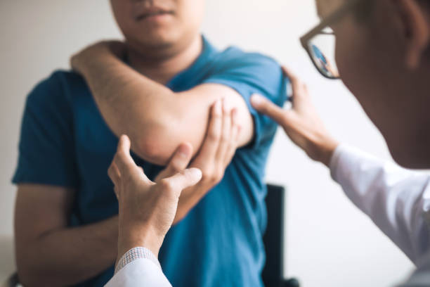 Physical therapists are checking patients elbows at the clinic office room. Physical therapists are checking patients elbows at the clinic office room. shoulder stock pictures, royalty-free photos & images