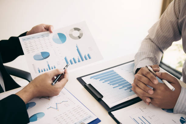 istock Two business partnership coworkers analysis strategy and gesturing with discussing a financial planning graph and company budget during a budget meeting in office room. 1152834810