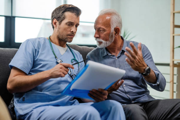 istock Doctor and senior patient discussing about medical documents during home visit. 1152834832