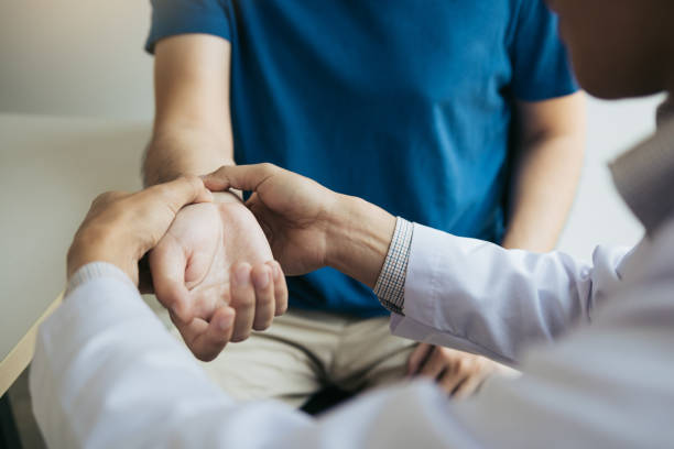 physical therapist checks the patient wrist by pressing the wrist bone in clinic room. - physical injury imagens e fotografias de stock