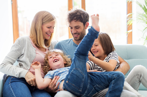 Portrait of happy family sitting on couch at home