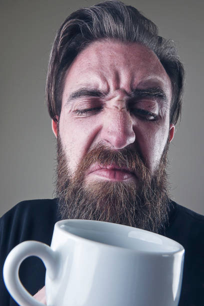 Close-up man with ugly coffee cup close-up man with ugly coffee cup awful taste stock pictures, royalty-free photos & images