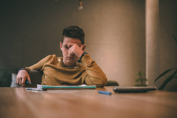 istock Tired 11 years old boy doing his homework at the table 1152838266