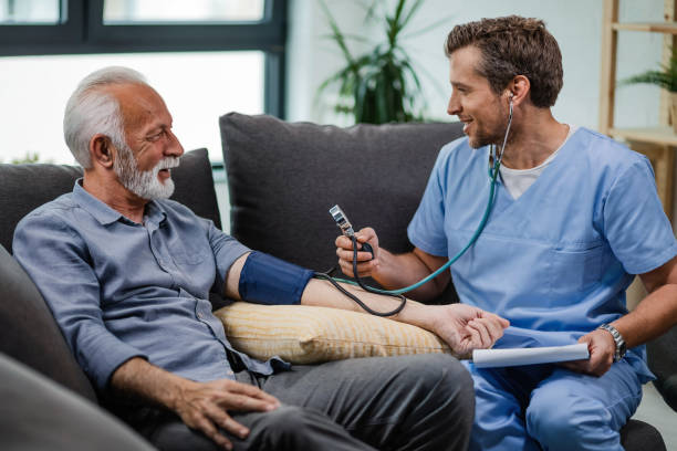 가정 방문에 있는 동안 성숙한 남자의 혈압을 측정 하는 행복 한 일반 개업. - nursing home nurse blood pressure gauge home caregiver 뉴스 사진 이미지