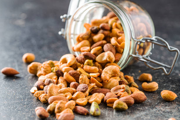 noci aromatizzate speziate. mix di noci. - nut spice peanut almond foto e immagini stock