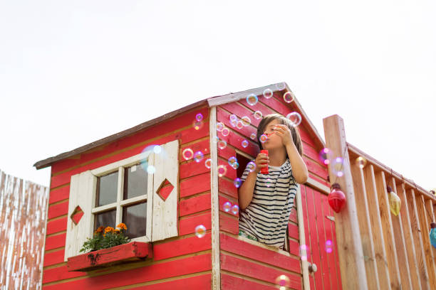 istock Boy blowing bubbles in a wooden playhouse 1152841216