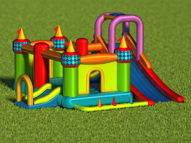 istock Multi-colored bouncy castle standing on grass against blue sky 1152841269