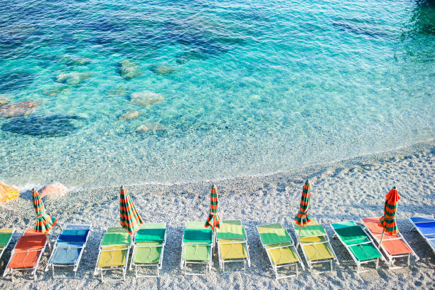 plage vide avec des parapluies fermés sur la côte italienne - cinque terre photos et images de collection