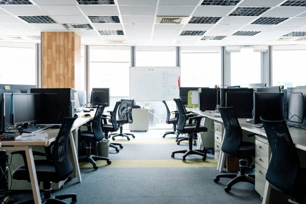 Empty chairs and Desktop PCs at desks in office Empty chairs at desks in office. Desktop PCs are on tables. Interior of modern work place with furniture. workplace absence stock pictures, royalty-free photos & images