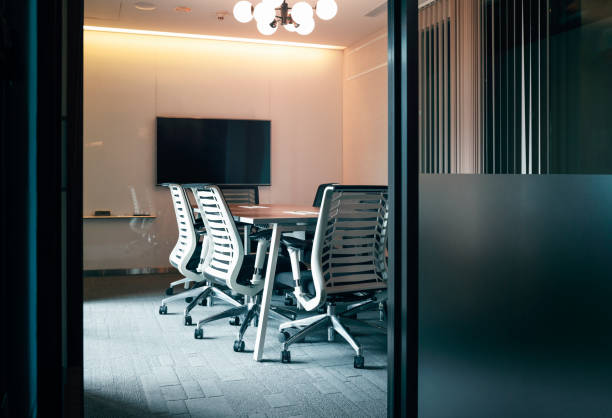 istock Illuminated chandelier hanging in board room 1152843141