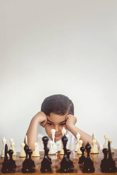 un pequeño niño de medio oriente juega al ajedrez - chess skill concentration intelligence fotografías e imágenes de stock