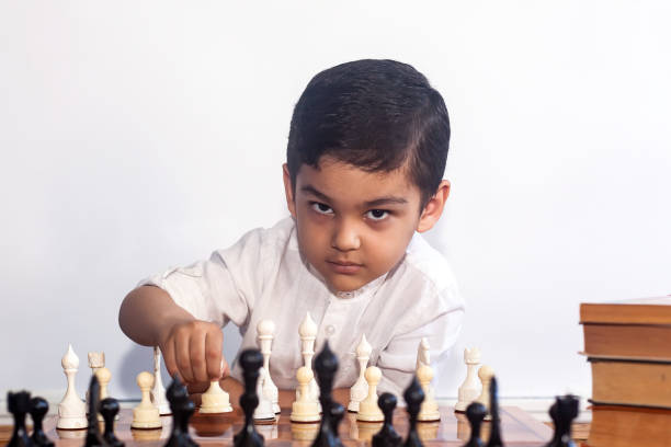 nachdenklicher junge, der schach spielt - concentration chess playing playful stock-fotos und bilder