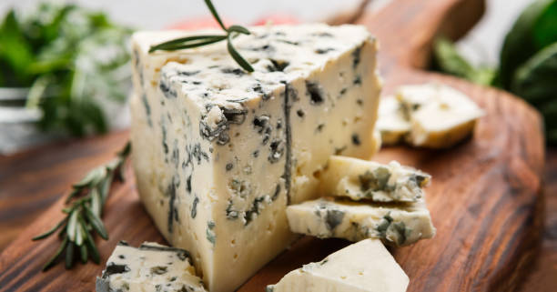 Blue cheese and rosemary Blue cheese and rosemary sprigs on wooden cutting board blue cheese stock pictures, royalty-free photos & images