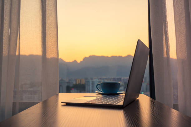 istock Laptop on wood table by window 1152850188