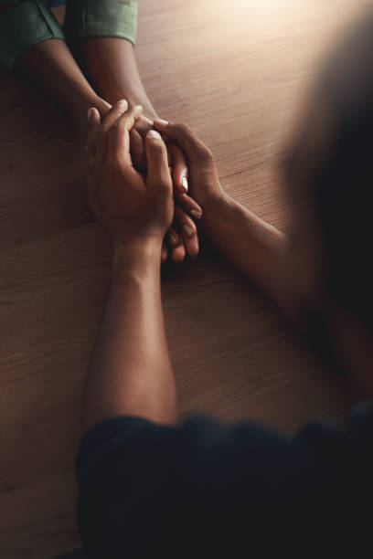 Man consoling girlfriend by holding her hands