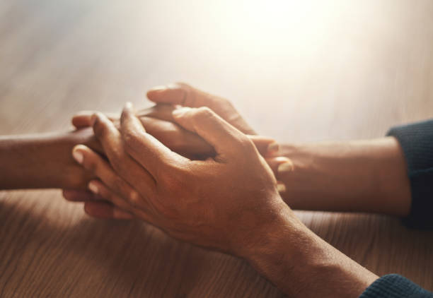istock Couple's hand holding hands on wooden desk 1152853195