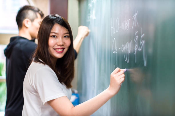 istock Asian university students writing on blackboard with a confident attitude 1152854798