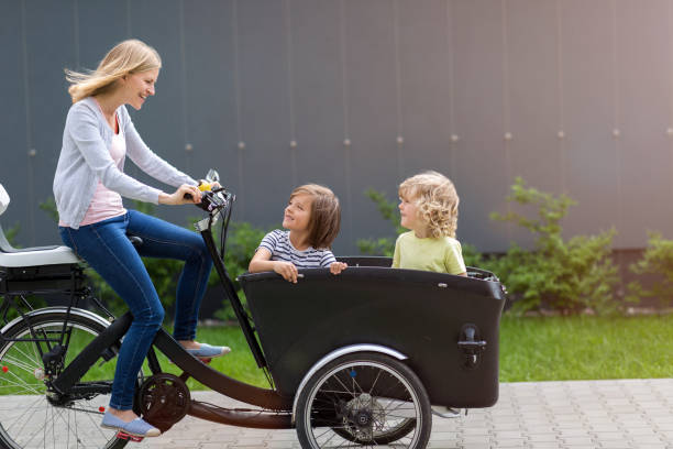 mor och barn har en tur med last cykel - parents children cargo bike bildbanksfoton och bilder