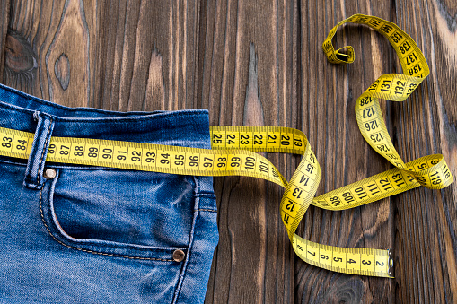 jeans, centimeter on a wooden background. diet. waist