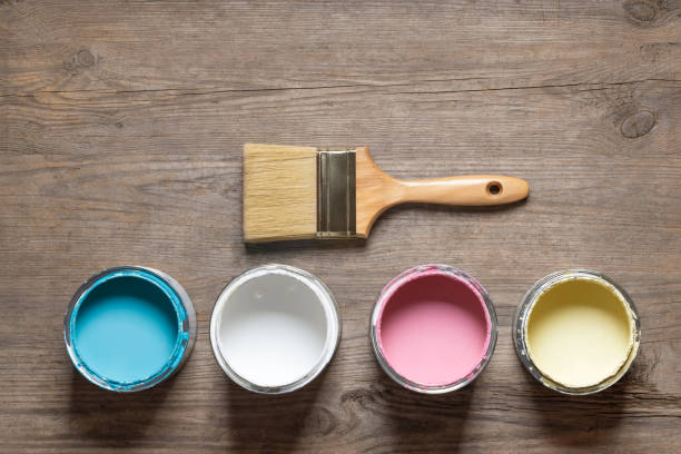 istock Paint brush and cans on wooden table 1152858632