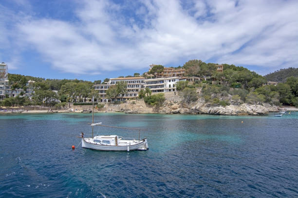 Pretty buildings Llaut Cala Fornells Sea Majorca SANTA PONSA, MALLORCA, SPAIN - MAY 29, 2019: Pretty buildings and moored llaut boat in Cala Fornells from sea on May 29, 2019 in Santa Ponsa, Mallorca, Spain. seaside views of cala fornells mallorca stock pictures, royalty-free photos & images