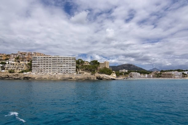 Hotel in Paguera from sea SANTA PONSA, MALLORCA, SPAIN - MAY 29, 2019: Hotel in Paguera from sea turquoise water on May 29, 2019 in Santa Ponsa, Mallorca, Spain. seaside views of cala fornells mallorca stock pictures, royalty-free photos & images
