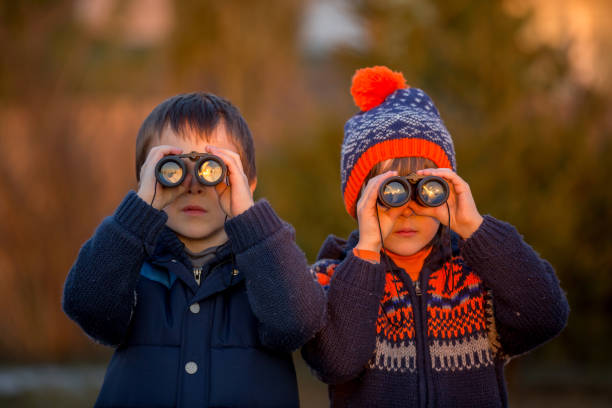 двое маленьких детей, мальчики, исследуя природу с биноклем - little boys discovery binoculars child стоковые фото и изображения