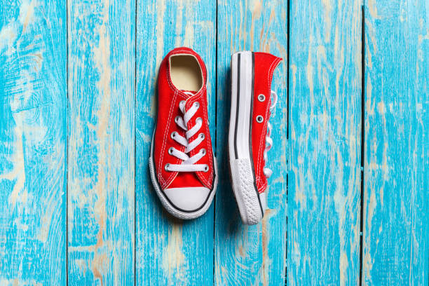 istock red sneakers on wooden background. 1152864010