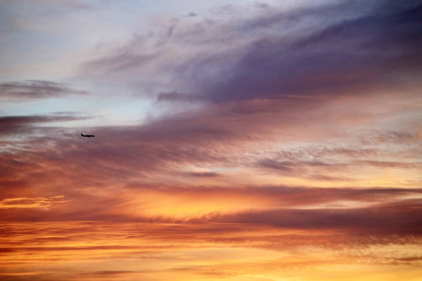 istock lonely plane in the orange sunset sky with many clods 1152865047