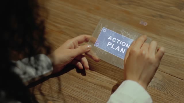 Hands hold tablet with text Action plan