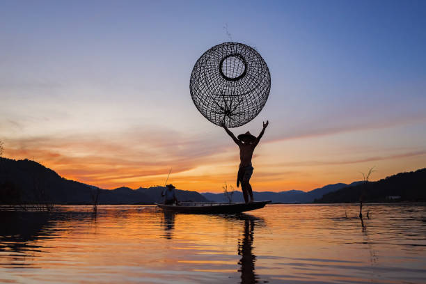 Fishermen fishing in the early morning golden light,fisherman fishing in the river,Thailand,Vietnam,myanmar,Laos